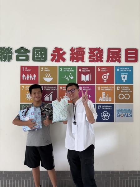 與小學伴交換禮物，非常開心帶著大學伴至學院的SDGs牆前合影留念